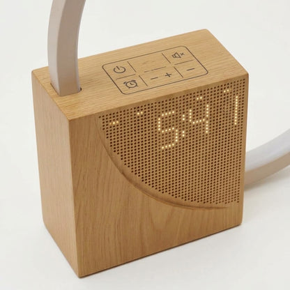 Lumiqia touch bedside lamp with alarm clock and natural sounds glowing on nightstand